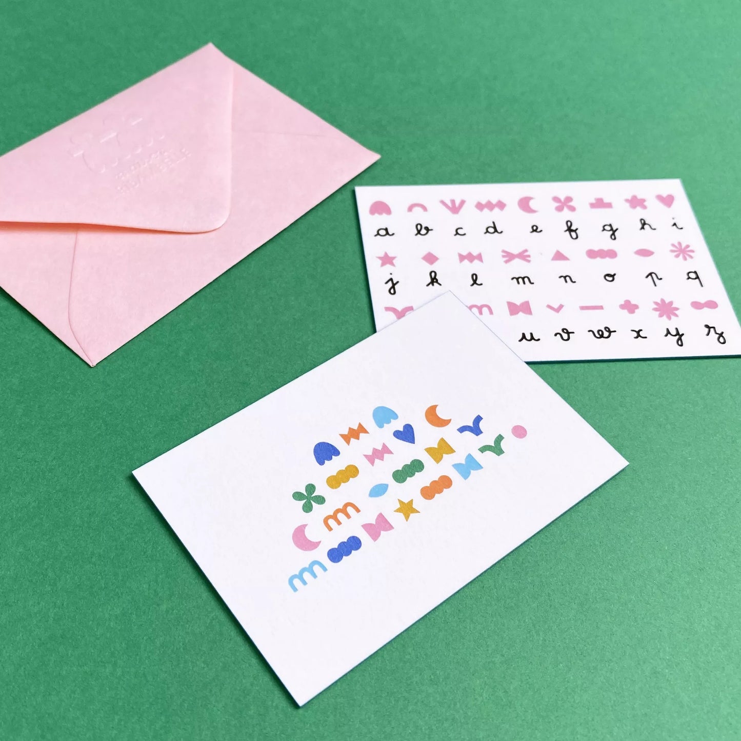 Carte à message codé "À la folie et pour toujours", avec son enveloppe rose et son alphabet pour déchiffrer le message.
