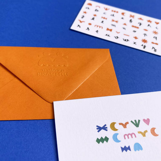 Carte à message codé "Merci d'être là", avec son enveloppe orange et son alphabet pour déchiffrer le message.