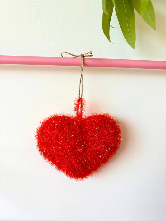 éponge lavable tawashi en forme de cœur rouge.