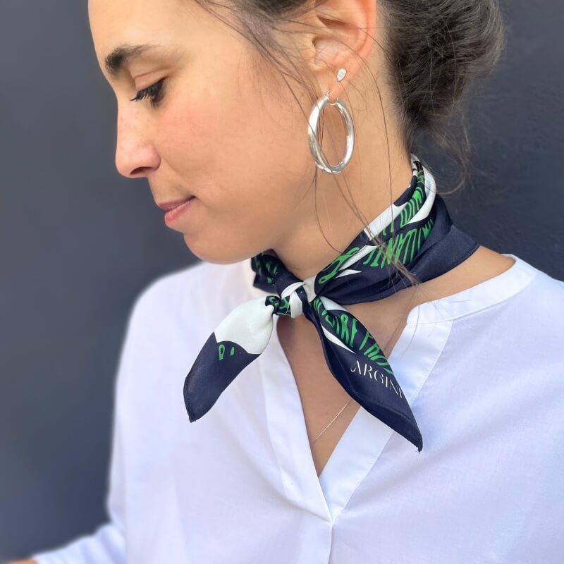 foulard en soie pour femme, avec des serpents vert et noir, noué au cou.