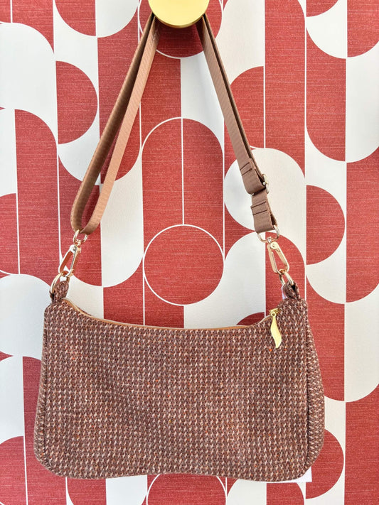 Sac baguette upcyclé en laine marron accroché à une patère dorée.