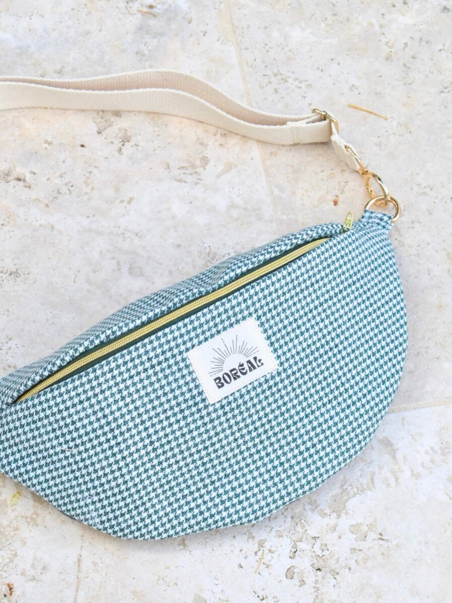 Sac banane pied de poule vert en laine avec une sangle beige.