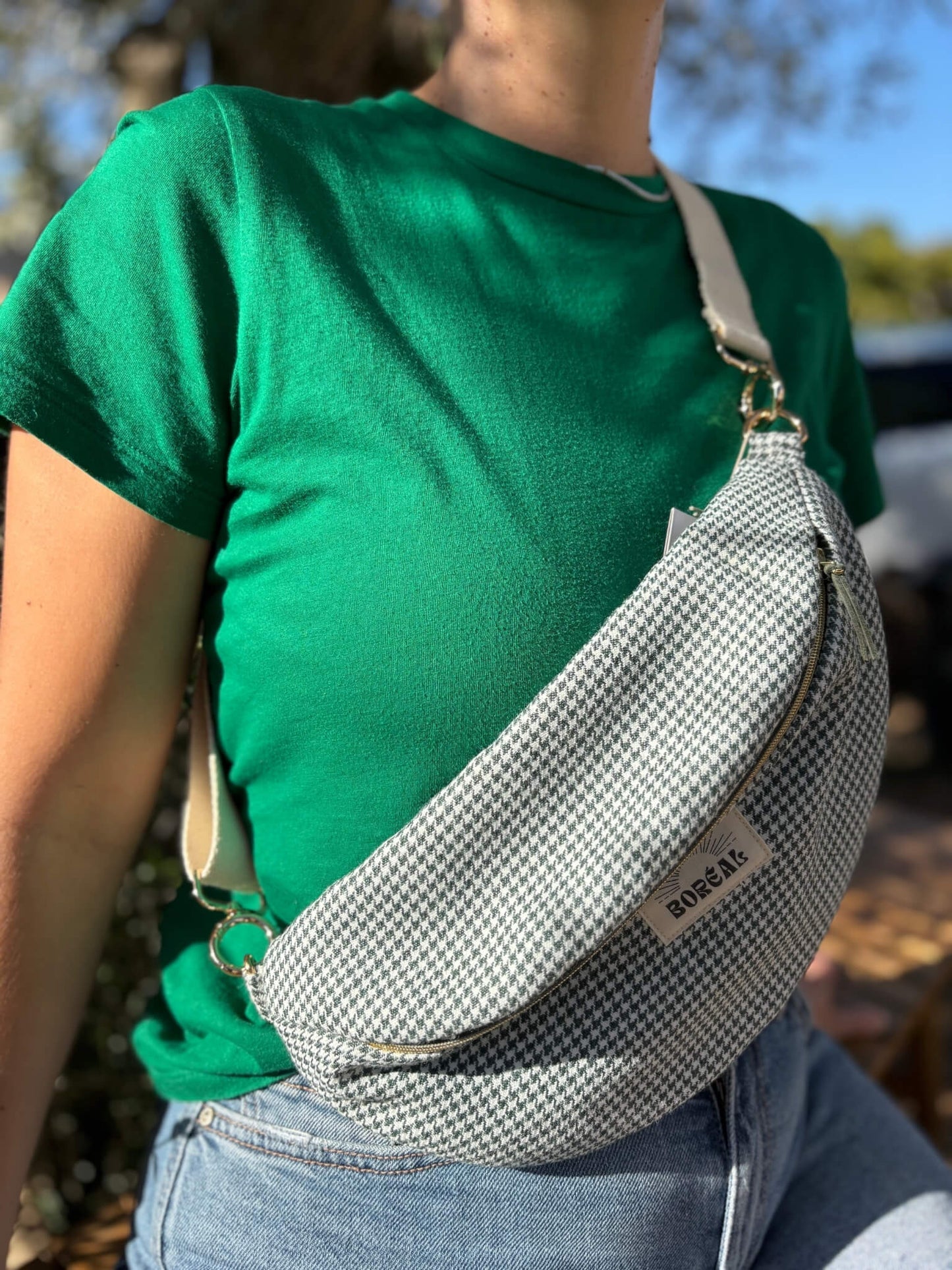 Sac banane pied de poule vert en laine avec une sangle beige.
