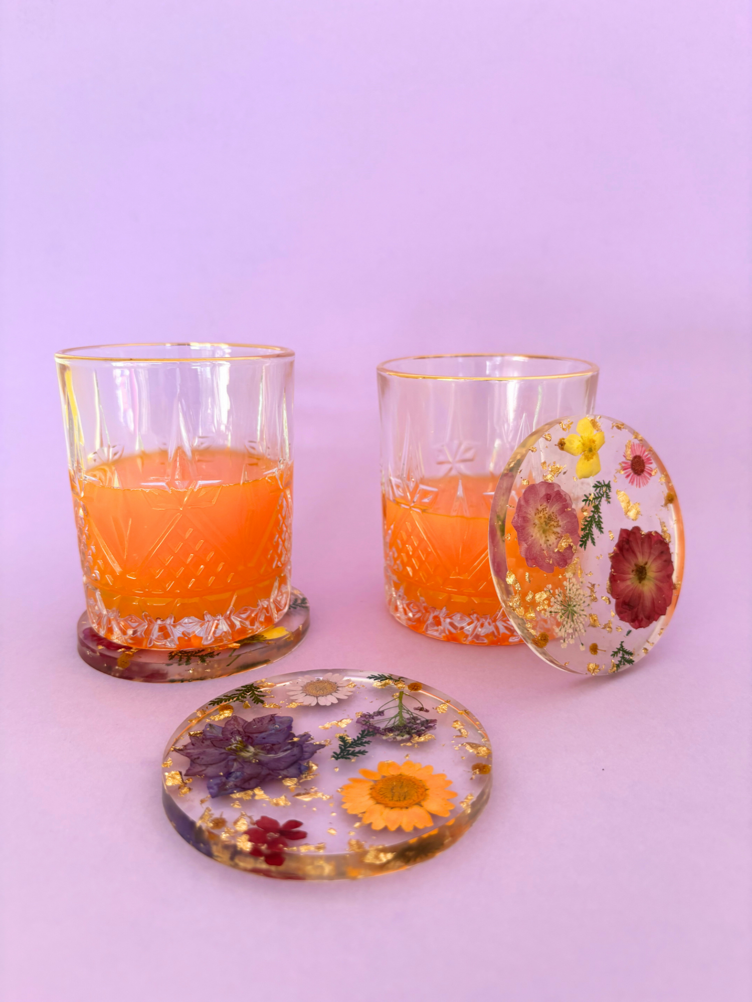 dessous de verres en résine et fleurs séchées avec verres de jus d'orange