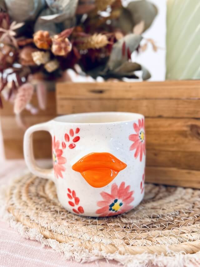 tasse/mug artisanal en céramique fabriqué en france, bouche orange flashy, fleurs colorés, orange, rose et jaune avec une anse