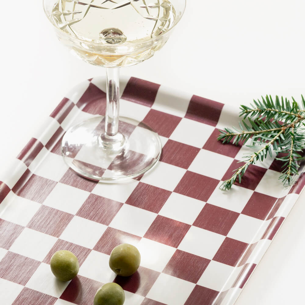 Plateau rectangulaire en bois certifié FSC, imprimé damier marron et blanc, avec une coupe de champagne.