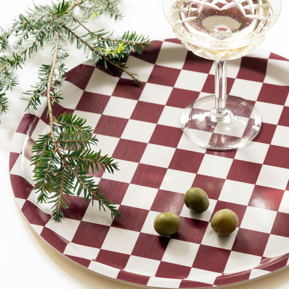 Plateau rond en bois certifié FSC, imprimé damier bordeaux et blanc, fabriqué en Suède.