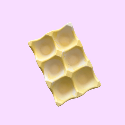 Rangement pour œufs artisanal et écologique jaune pastel.