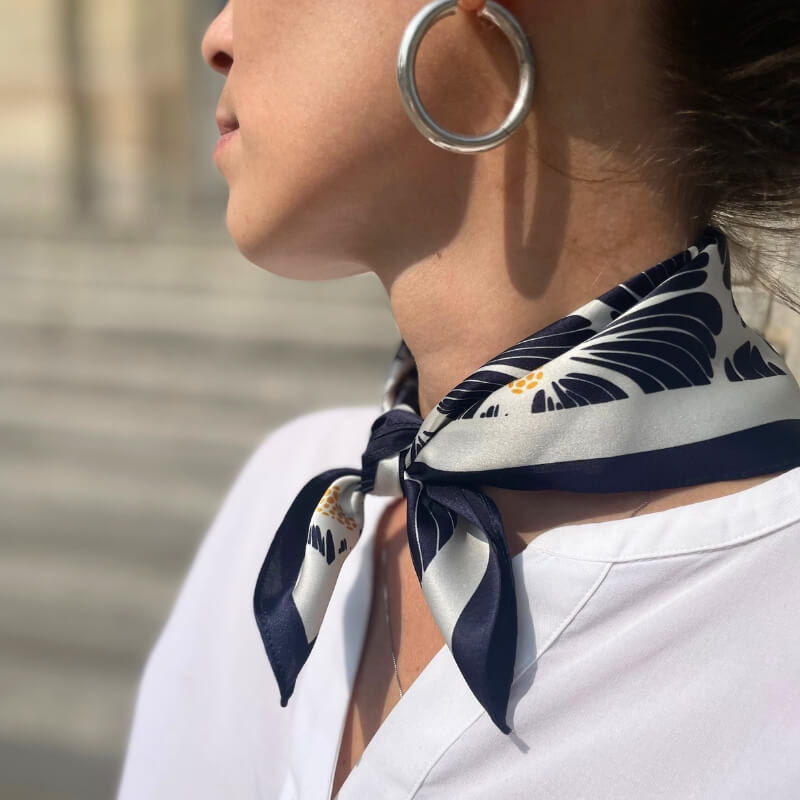 foulard en soie à fleurs pour femme, noir et blanc, noué autour du cou.