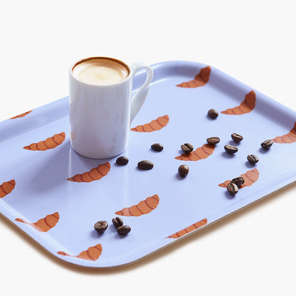 Plateau rectangulaire violet en bois avec des croissants et un café.