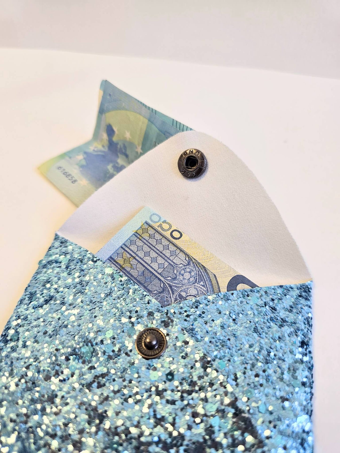 Porte-monnaie bleu à paillettes ouvert.