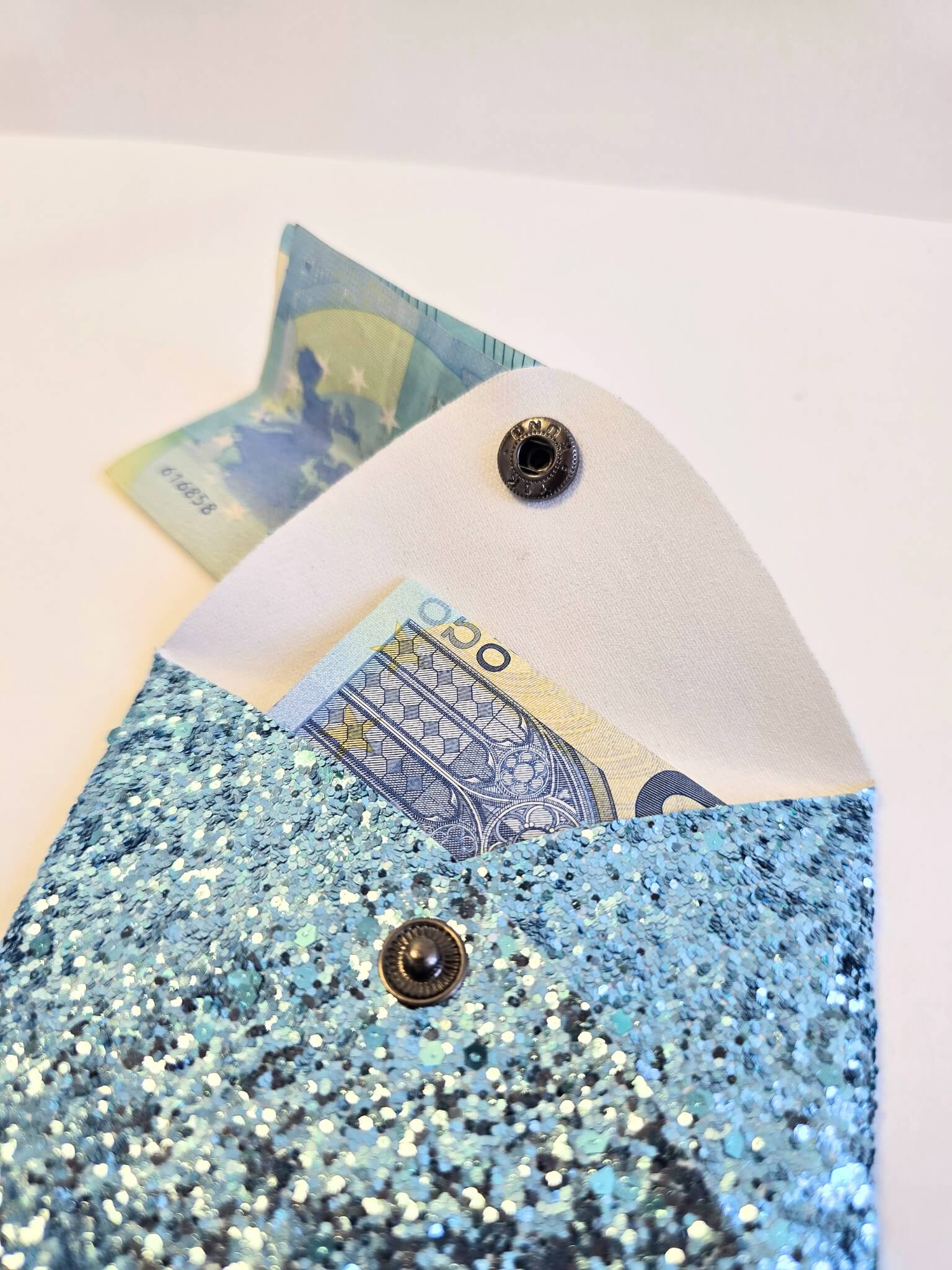 Porte-monnaie bleu à paillettes ouvert.