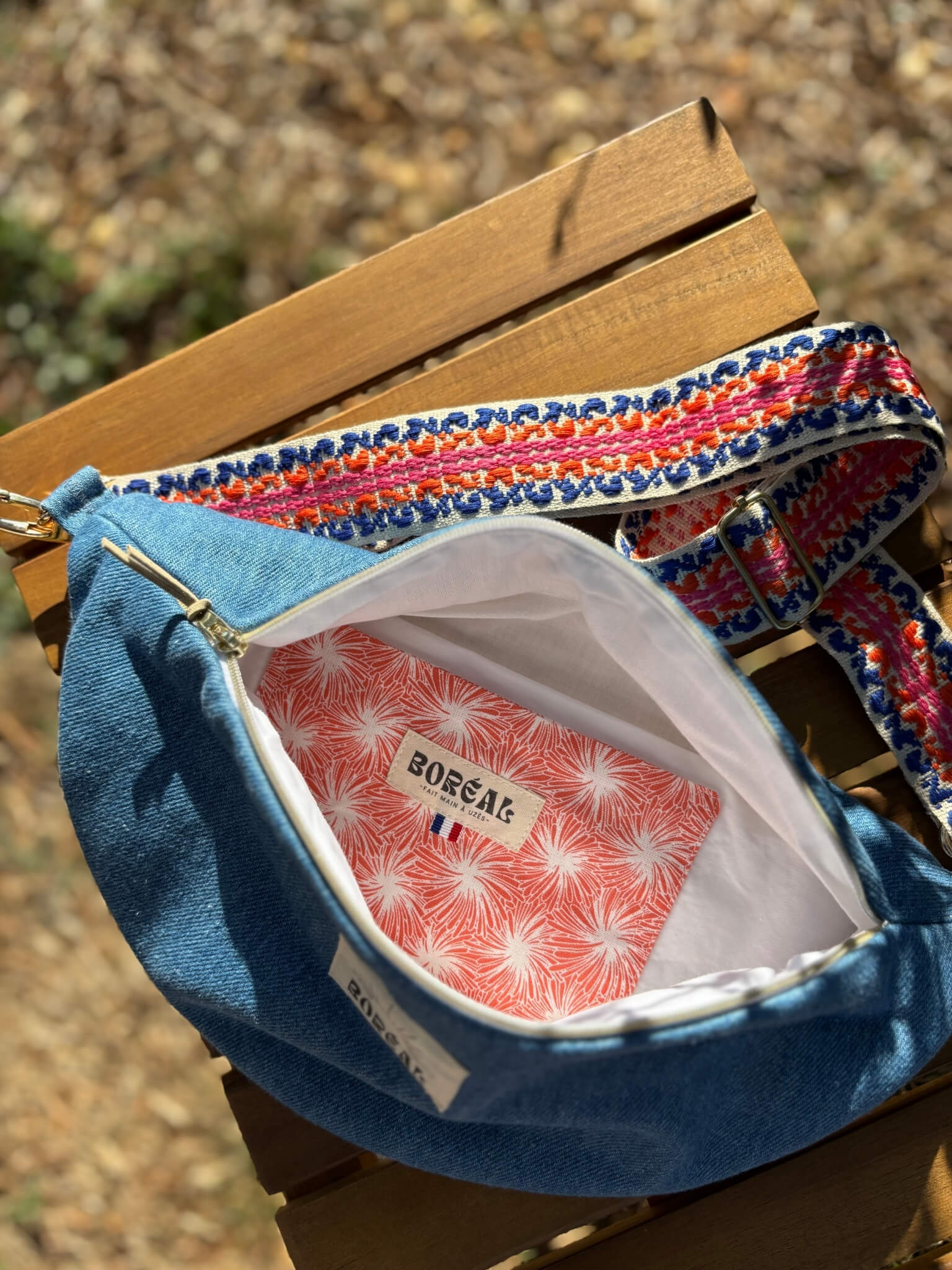Sac banane bleu en jean, avec une sangle colorée réglable.