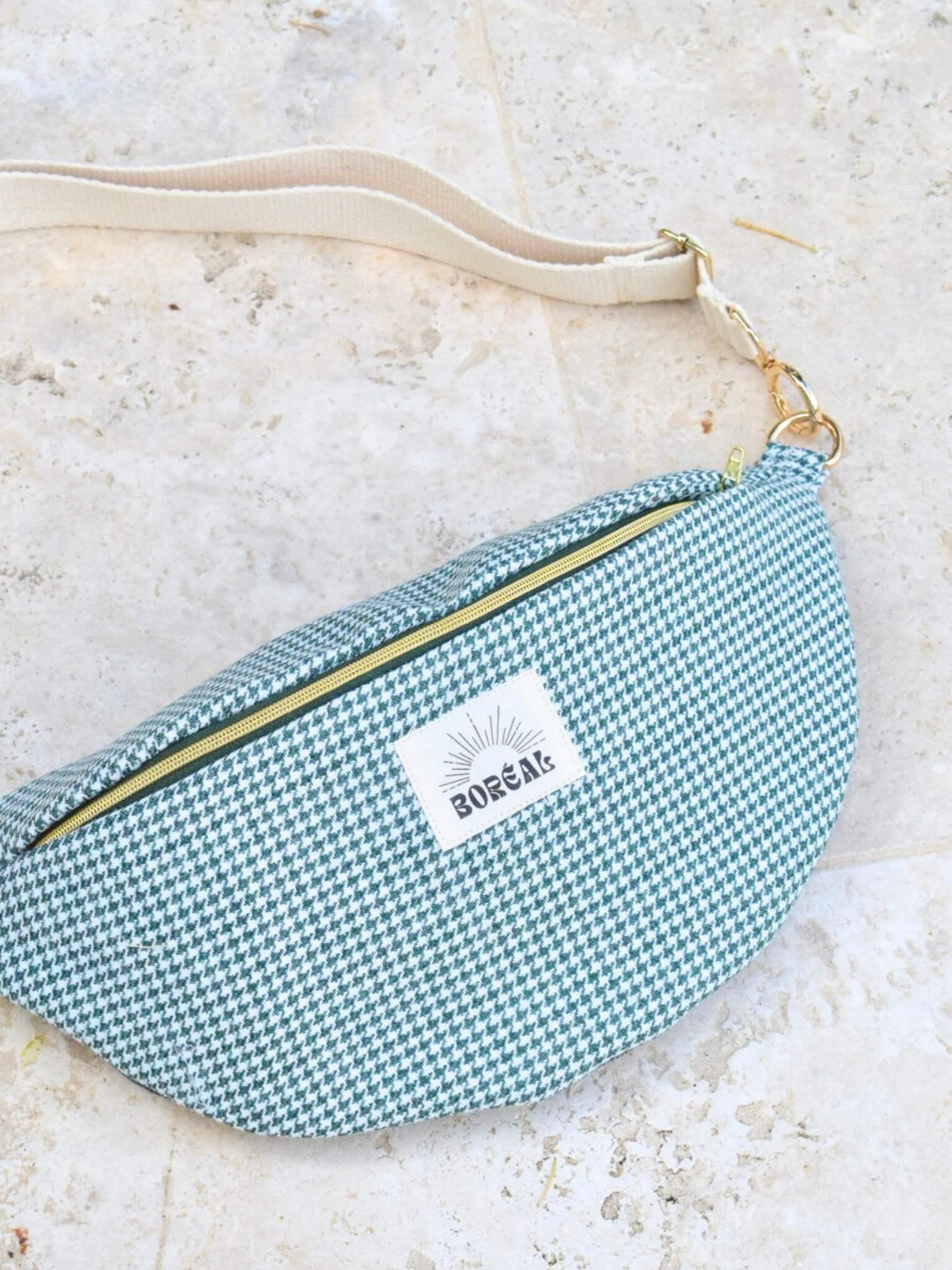 Sac banane pied de poule vert en laine avec une sangle beige.