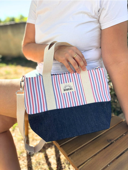 Sac à bandoulière en jean et coton rayé, avec une sangle beige réglable.