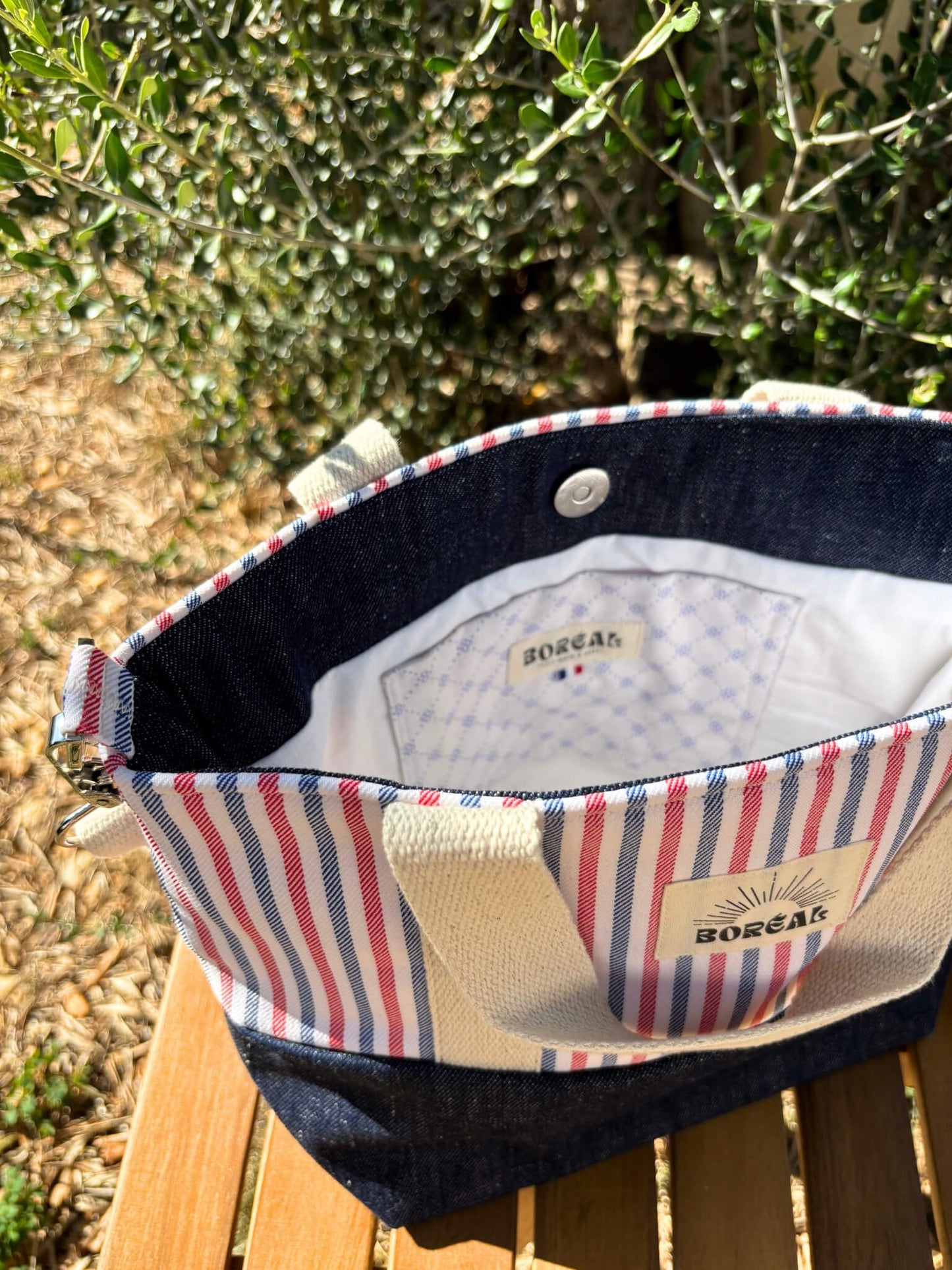 Sac à bandoulière en jean et coton rayé, avec une sangle beige réglable.