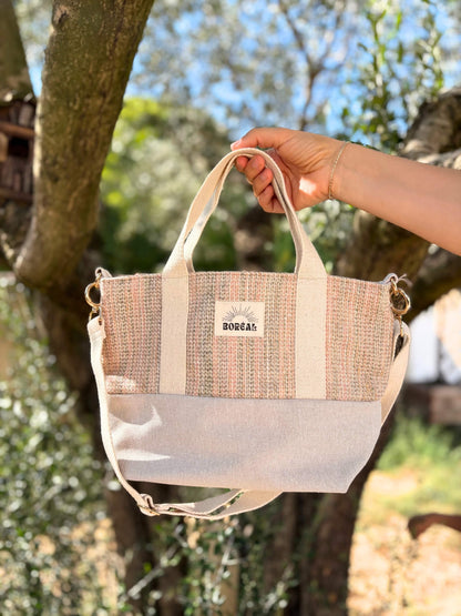 Sac à bandoulière en laine beige, avec une sangle beige réglable.