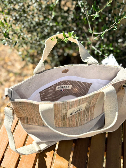 Sac à bandoulière en laine beige, avec une sangle beige réglable.