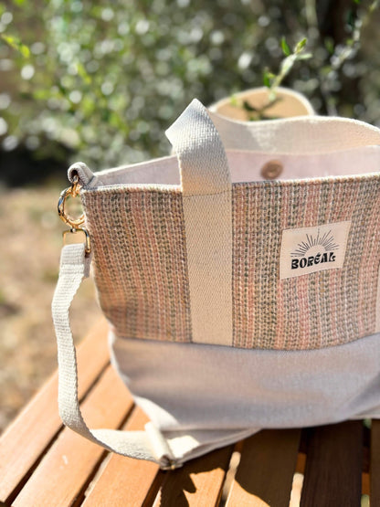 Sac à bandoulière en laine beige, avec une sangle beige réglable.