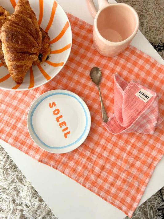 set de table en gaze de coton vichy orange avec des assiettes et des viennoiseries