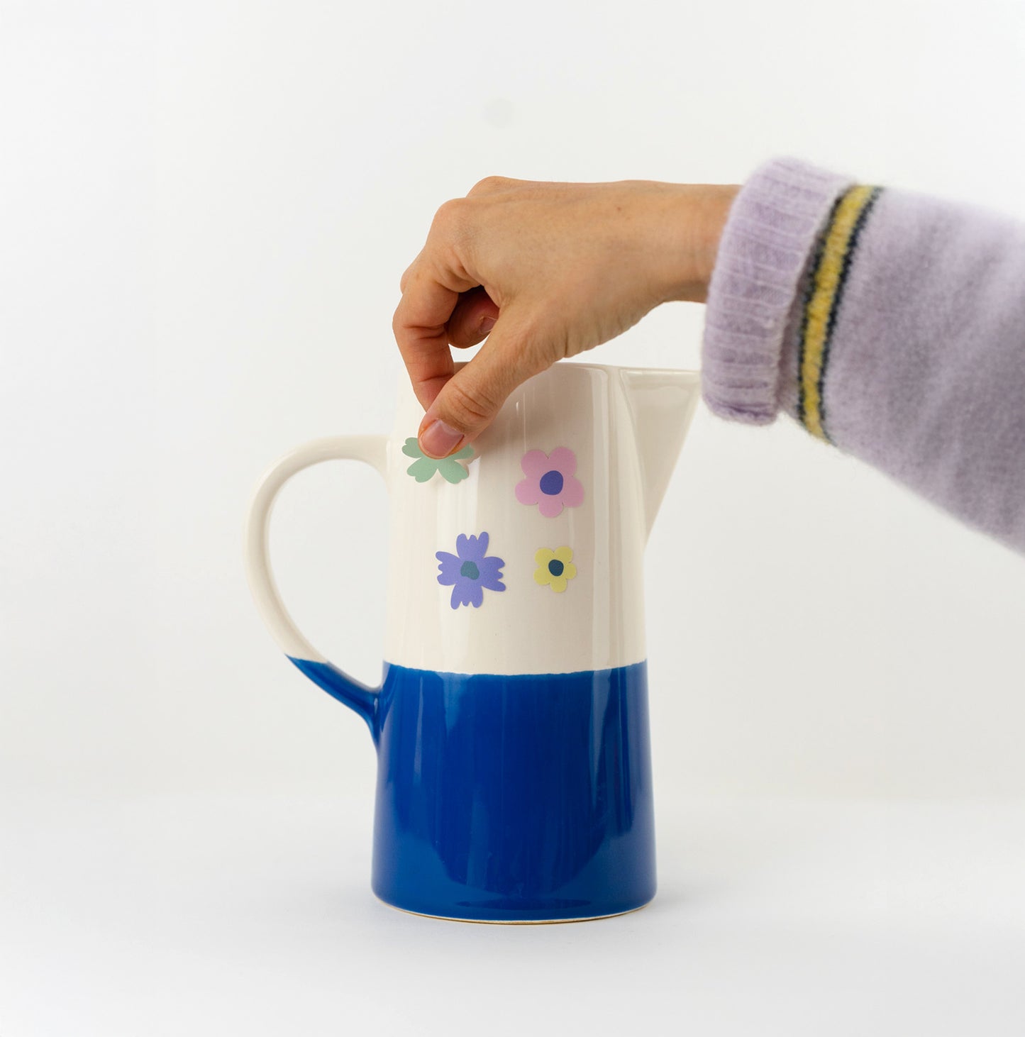 Stickers fleurs collés sur un vase en céramique.