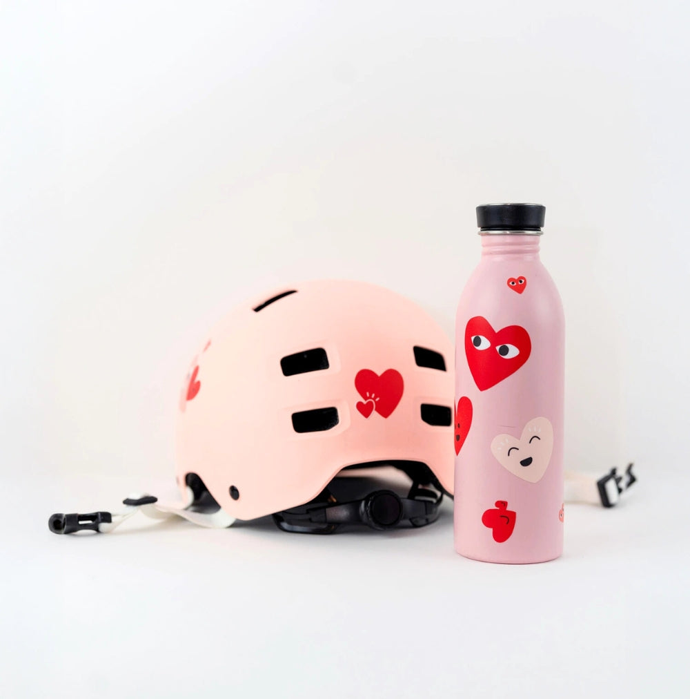 Stickers cœurs rouges collés sur une gourde et un casque.