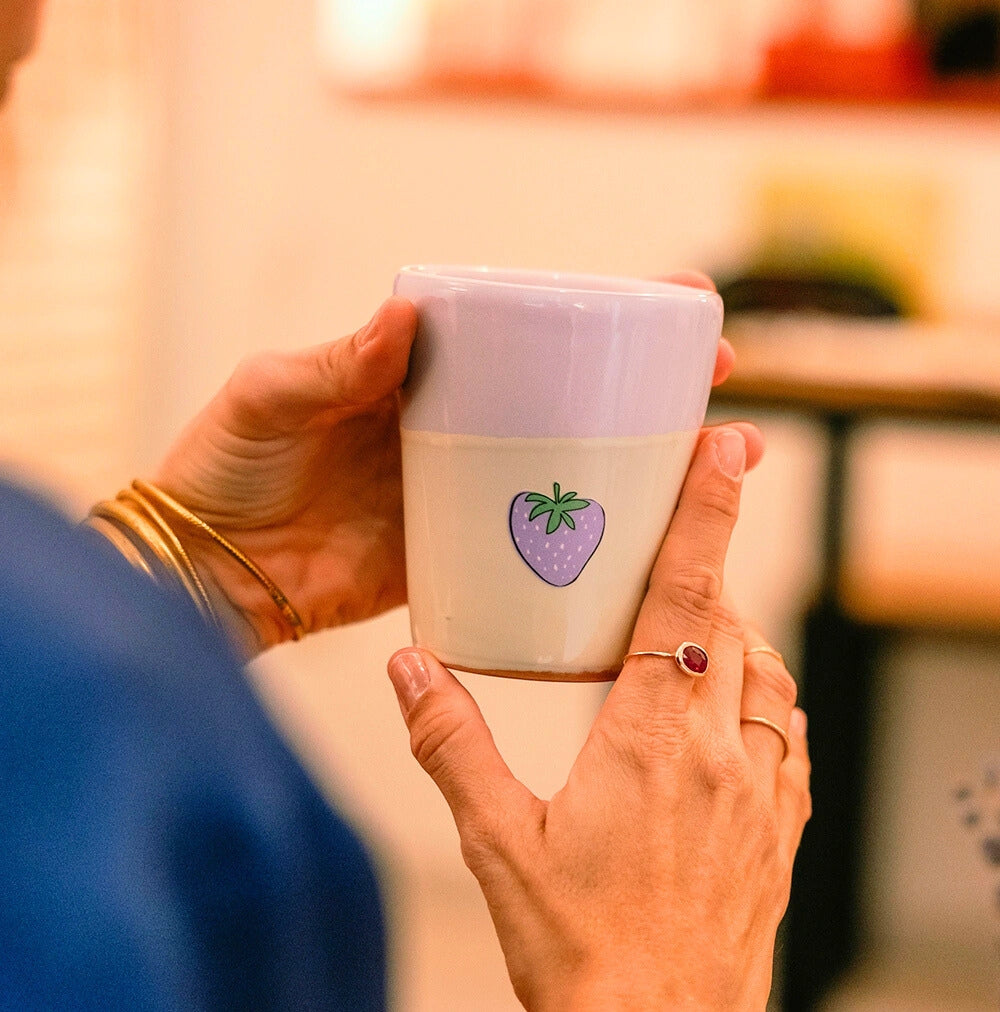 Sticker fraise violette collé sur une tasse.
