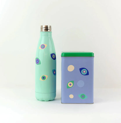 Stickers yeux porte-bonheur, collés sur une gourde et une boite en métal.
